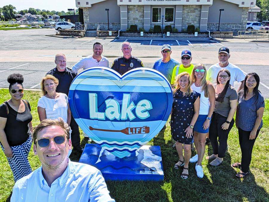 A group poses in front of a heart sculpture in Lake Winnebago for City Hall Selfie Day